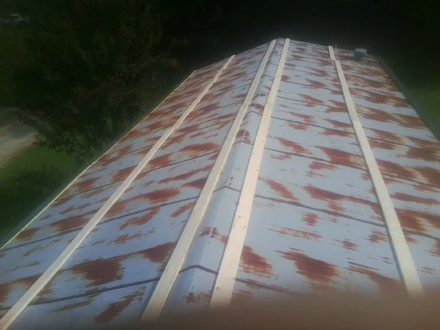 Rusted metal roof panels with new wood purlins before replacement — Storm Damage Roof Repair in Sumter by Roofing Brothers