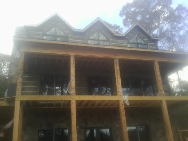 Dormers and porch framing on a large log home under construction — Roof Coating work by our crew in Sumter