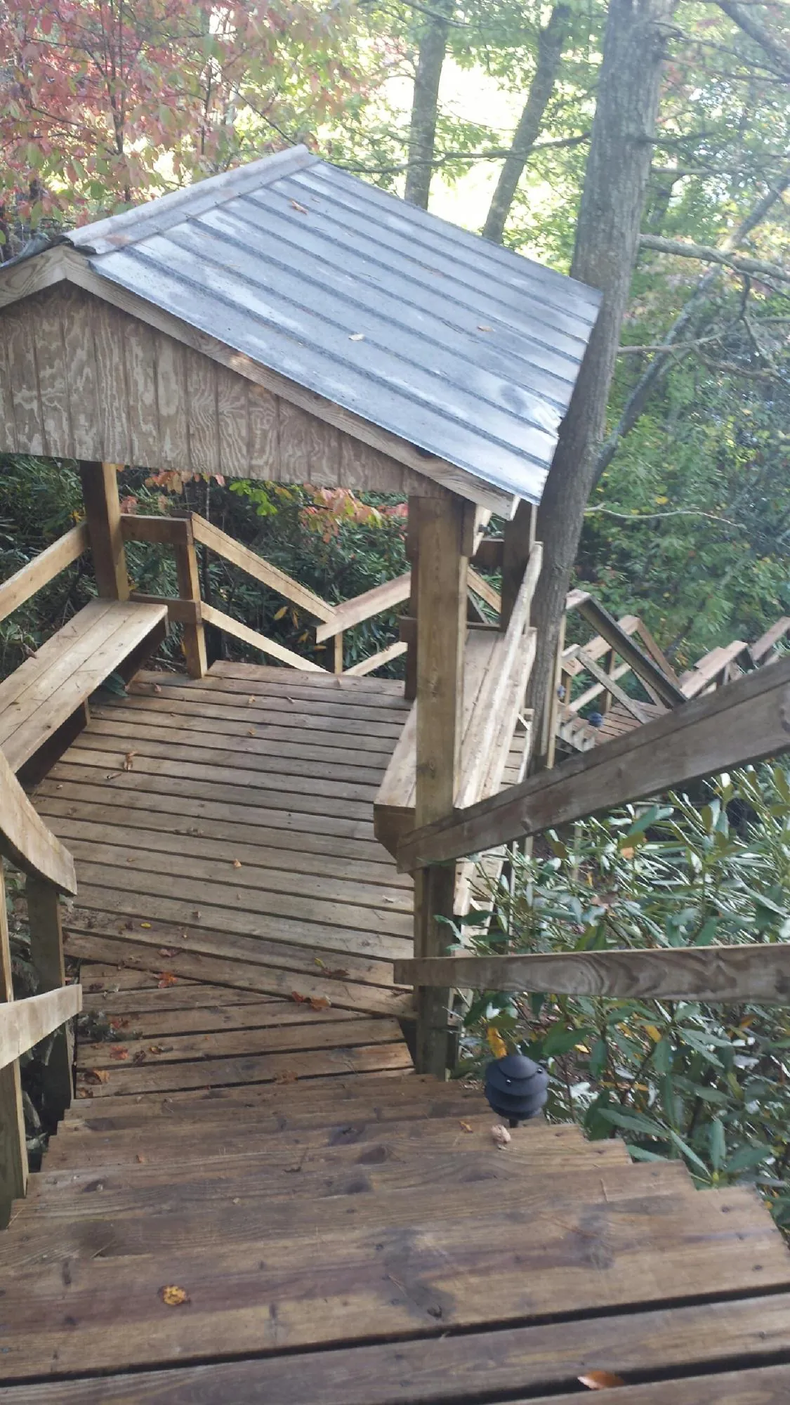 Metal roofed shelter over wooden steps on a wooded walkway — Skylight Repair & Installation work by our crew in Sumter