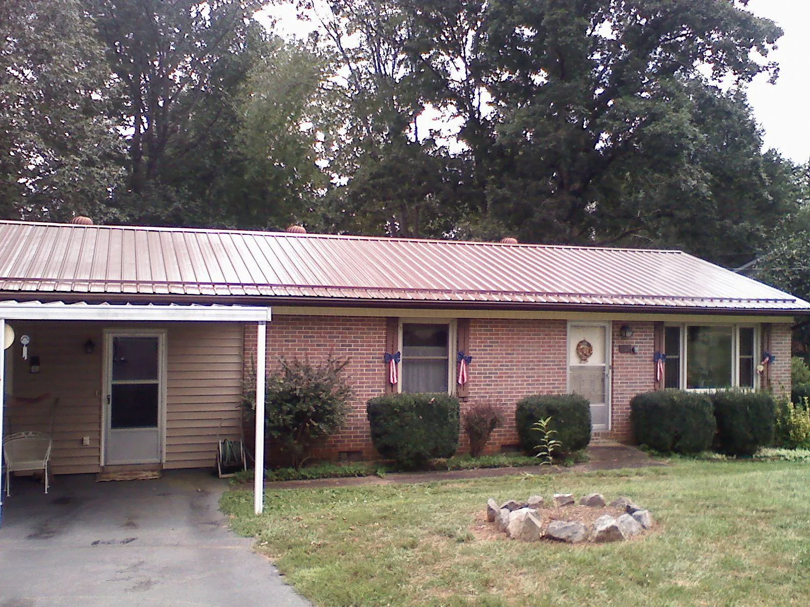 Bronze metal roof and carport on a brick ranch home — Roof Repair work by our crew in Sumter